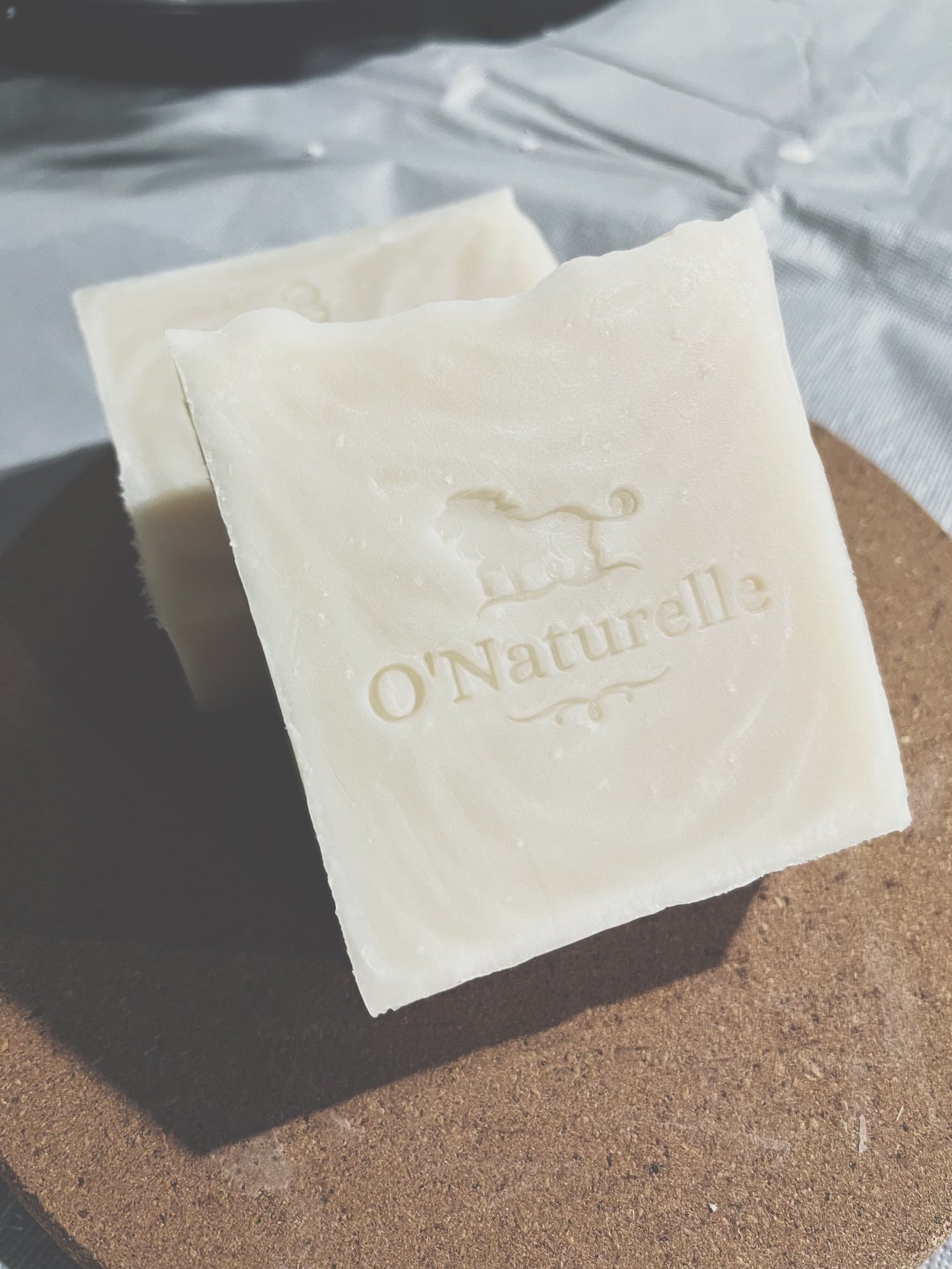 Multiple bars of O'Naturelle beef tallow soap stacked amongst eachother.